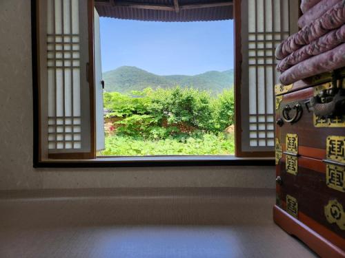 una ventana abierta con vistas a la montaña en Hanok Soeun House en Miryang