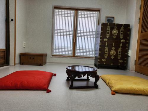 MiryangにあるHanok Soeun Houseのテーブル、ソファ、コーヒーテーブルが備わる客室です。
