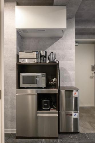a kitchen with a microwave and a refrigerator at RAKU Hotel Tokyo Bay Front in Tokyo
