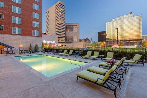 a swimming pool with lounge chairs and a city skyline at King & Queen in Downtown Columbus in Columbus