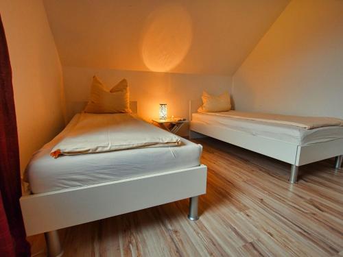 - 2 lits dans une petite chambre aux murs orange dans l'établissement Semi-detached house, Hasselfelde, à Hasselfelde
