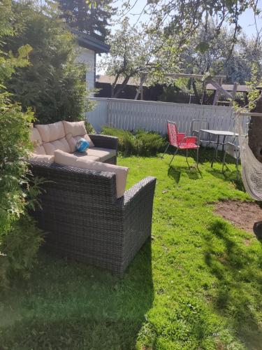 a couch sitting in the grass in a yard at Karjamaa Apartment - Garden, Free parking, Air conditioning in Pärnu