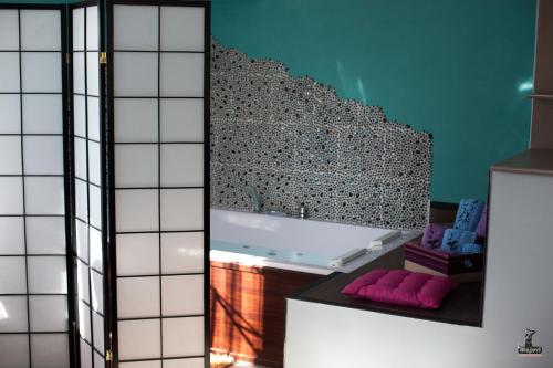 a bathroom with a white tub and a mirror at Alojamiento Nohal in La Iruela