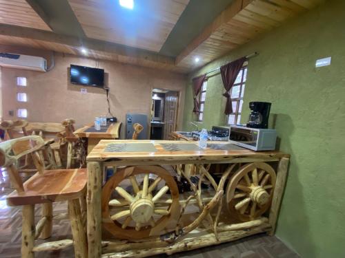 a kitchen with a wooden cart with a microwave on it at Cabañas Rochivo Ranch in Creel