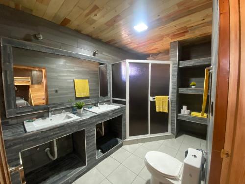 uma casa de banho com 2 lavatórios e um chuveiro em Cabañas Rochivo Ranch em Creel
