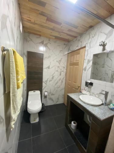 a bathroom with a white toilet and a sink at Cabañas Rochivo Ranch in Creel