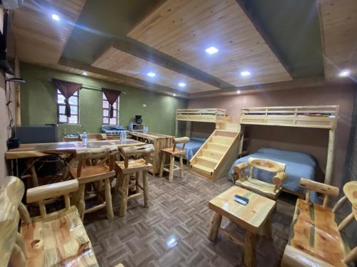 a room with bunk beds and a table and chairs at Cabañas Rochivo Ranch in Creel