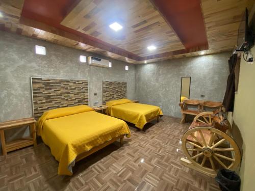 Cette chambre comprend 2 lits et une roue. dans l'établissement Cabañas Rochivo Ranch, à Creel