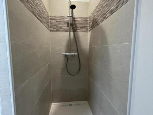 a shower with a shower head in a bathroom at Séjour détente avec piscine privée, activités variées et confort moderne en Auvergne - FR-1-489-455 in Louroux-Hodement