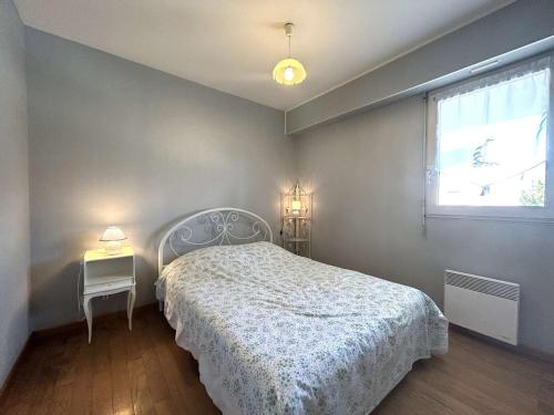 une chambre avec un lit blanc et une fenêtre dans l'établissement Appartement cosy 2 pièces avec parking à St-Gilles-Croix-de-Vie - FR-1-224-801, à Saint-Gilles-Croix-de-Vie