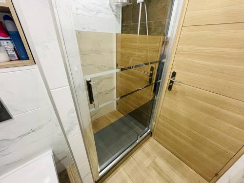 d'une porte de douche en verre avec du parquet. dans l'établissement Appartement rénové, proche port et plage, parking inclus - FR-1-723-107, au Cap d'Agde