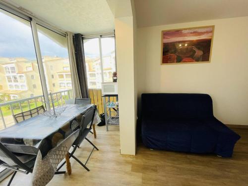 une pièce avec une table, une chaise et une fenêtre dans l'établissement Appartement rénové, proche port et plage, parking inclus - FR-1-723-107, au Cap d'Agde