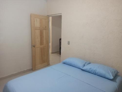 1 cama con almohada azul en una habitación en Casita Mahahual 2, Grand Costa Maya en Mahahual