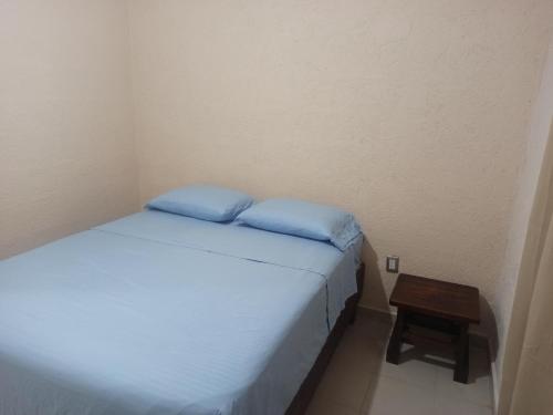a small bedroom with a bed and a table at Casita Mahahual 2, Grand Costa Maya in Mahahual