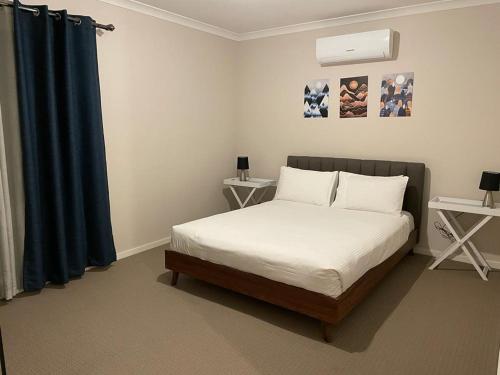 ein Schlafzimmer mit einem Bett und einem blauen Vorhang in der Unterkunft Rise Traralgon in Traralgon