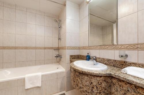 a bathroom with a sink and a bath tub at Luxury Princess Tower 1 Br Brand New Furnished apartment in Dubai