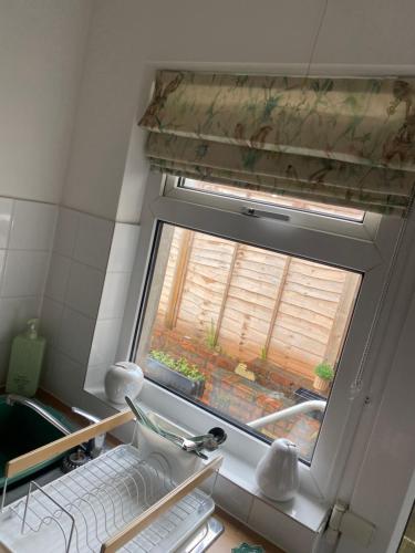 a window in a small kitchen with a sink at Ty Pentref - Cwmcarn Village House in Cwmcarn