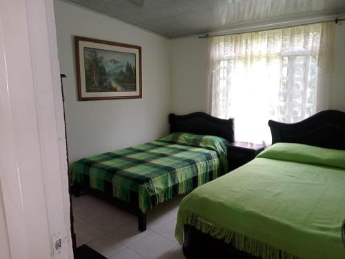1 Schlafzimmer mit 2 Betten und einem Fenster in der Unterkunft Casa de campo los anturios in La Tebaida