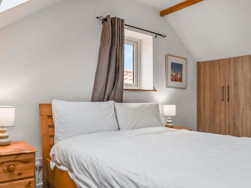 1 dormitorio con cama blanca y ventana en The Hay Barn-uk41602 en Stainton