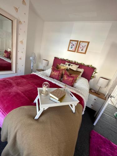 Un dormitorio con una cama y una mesa con libros. en Ty Pentref - Cwmcarn Village House en Cwmcarn