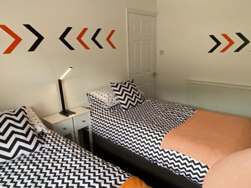 two beds sitting next to each other in a room at Ty Pentref - Cwmcarn Village House in Cwmcarn