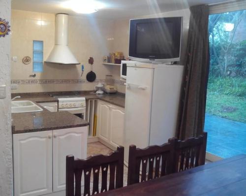 a kitchen with a tv on top of a refrigerator at El lugar in Villa Gesell