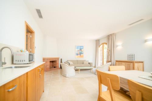 eine Küche und ein Wohnzimmer mit einem Sofa und einem Tisch in der Unterkunft Relais du vieux sauvaire in Le Lavandou