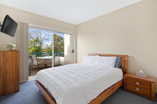 une chambre avec un lit et une télévision et un balcon dans l'établissement Sunrise Ocean Views Retreat Cowes Phillip Island, à Cowes