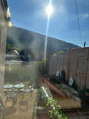 a view of a backyard with a table and chairs at Ty Pentref - Cwmcarn Village House in Cwmcarn