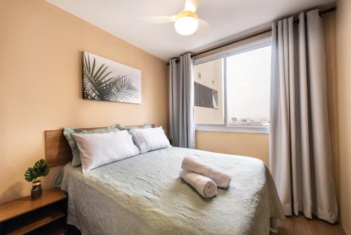 a bedroom with a bed with a large window at 92B Apto Confortável Prox ao Bras - Piscina e academia in Sao Paulo