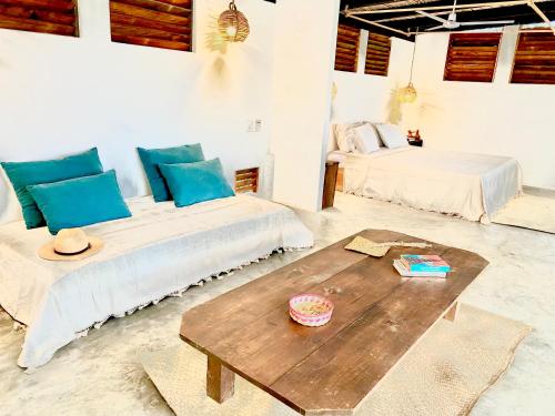 a bedroom with two beds and a wooden table at El Eden Escondido in Puerto Escondido