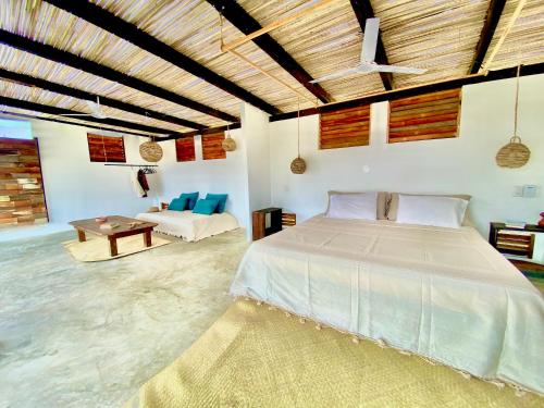 a large bedroom with a bed and a couch at El Eden Escondido in Puerto Escondido