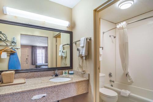 La salle de bains est pourvue d'un lavabo, de toilettes et d'un miroir. dans l'établissement Quality Inn & Suites, à Santee