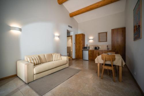 ein Wohnzimmer mit einem Sofa und einem Tisch in der Unterkunft Relais du vieux sauvaire in Le Lavandou