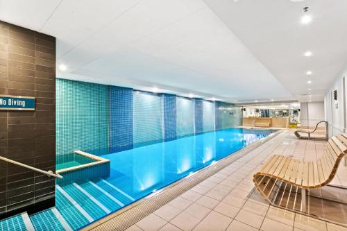 a swimming pool with a bench in a building at Belle Escapes - Beachfront Balcony Glenelg in Glenelg