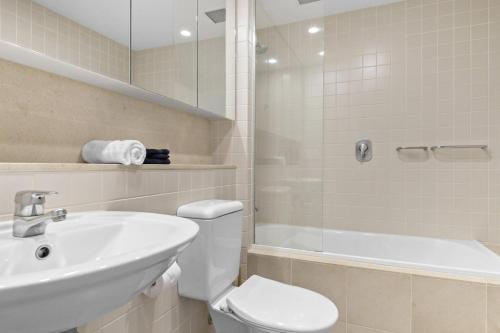 a bathroom with a sink and a toilet and a shower at Belle Escapes - Park View Studio at The Pier in Glenelg