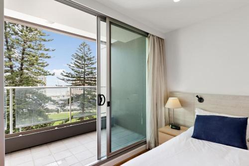 a bedroom with a bed and a large window at Belle Escapes - Lazy Days on Colley Terrace in Glenelg