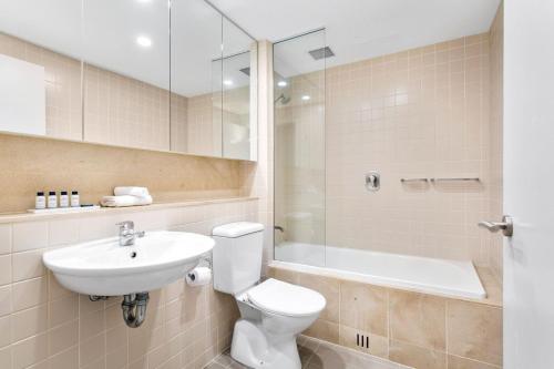 ein Bad mit einem WC, einem Waschbecken und einer Dusche in der Unterkunft Belle Escapes - Park View Family Stay at the Pier in Glenelg