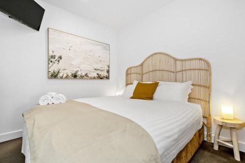 a bedroom with a large bed with a wooden headboard at Belle Escapes - Park View Apartment at The Pier in Glenelg