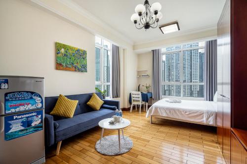 胡志明市的住宿－The Manor 2 Luxury Apartment Free roof top pool，客厅配有蓝色的沙发和床。