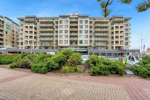 a large apartment building with bushes in front of it at Belle Escapes - Park View Apartment at The Pier in Glenelg