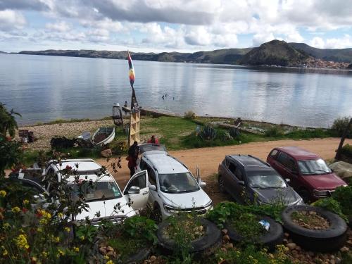 a group of cars parked next to a body of water at Kasa Kultural Sol y Luna in Copacabana
