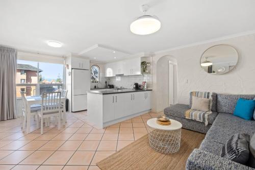 a living room and kitchen with a couch and a table at Belle Escapes - Sunny Siesta at Glenelg in Glenelg