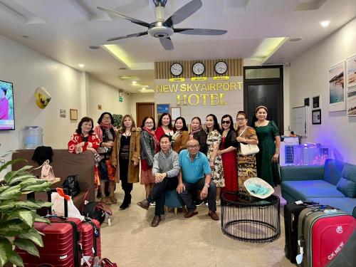 a group of people standing in a room with luggage at New Sky Airport Hotel in Noi Bai