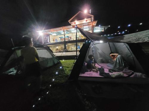 a group of people sitting inside a tent at night at Lipis Riverfront Resort in Kuala Lipis