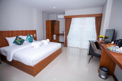 una camera d'albergo con letto, scrivania e computer di The Brown Boutique Patong a Patong Beach