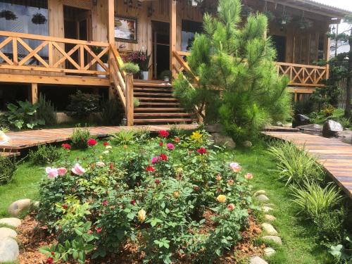 a garden with flowers in front of a house at Dớt's Garden Homestay in Da Lat