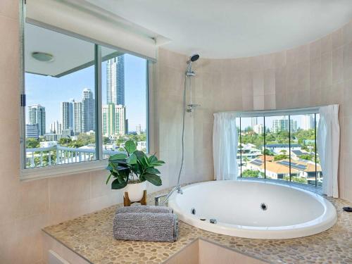 a bathroom with a tub and a large window at Quiet location close to it all in Gold Coast