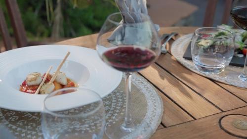 a table with a glass of wine and a plate of food at Hôtel Beau Soleil in Le Lavandou