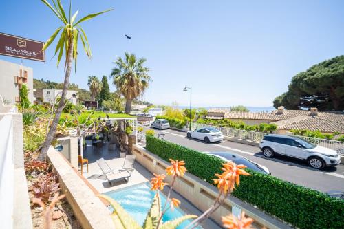 a view of a street with cars parked in a parking lot at Hôtel Beau Soleil in Le Lavandou